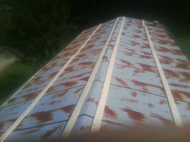 Rusted metal roof panels with new wood purlins before replacement — Storm Damage Roof Repair in Minerva by Roofing Brothers