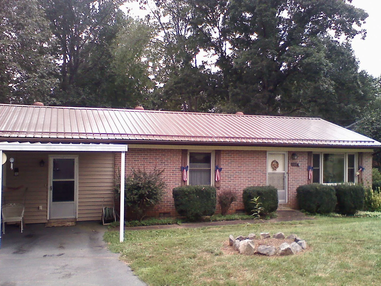 Bronze metal roof and carport on a brick ranch home — Roof Repair work by our crew in Minerva